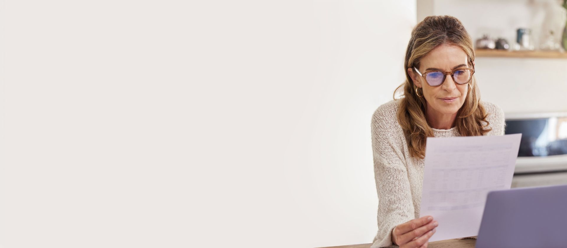 Vrouw met bril bekijkt EOS-brief aan bureau – betaal openstaande vorderingen eenvoudig