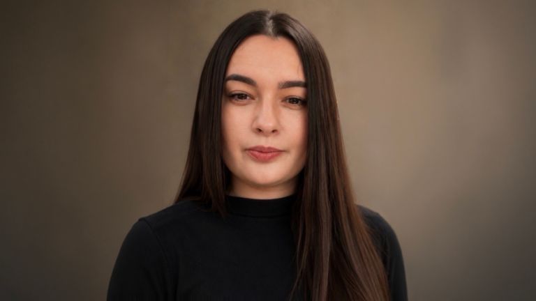 Daniela Moaca, Senior Manager IT bij EOS Romania, portretfoto in een donkere coltrui.