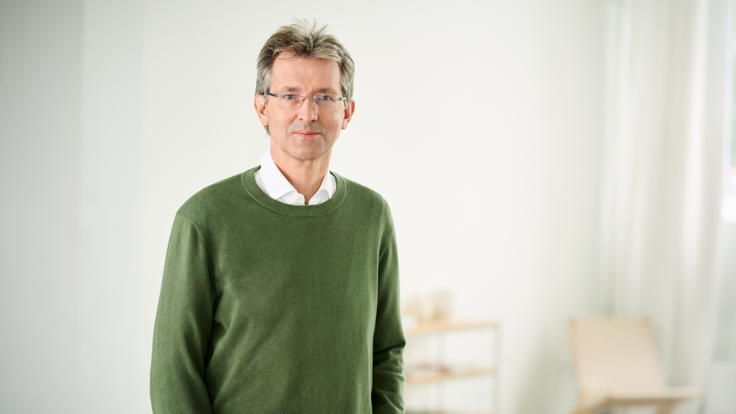 Justus Hecking-Veltman, CFO, staat met een woudgroene trui en wit hemd in een lichte ruimte.