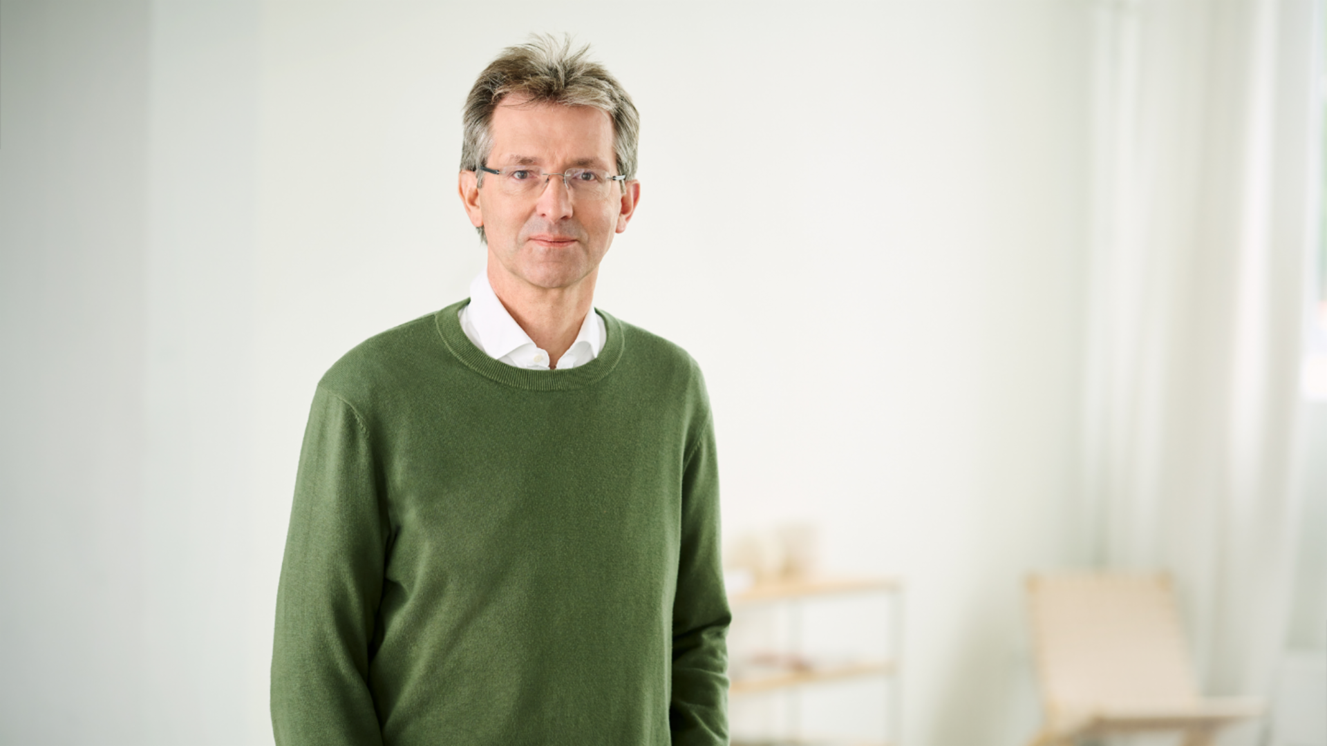 Justus Hecking-Veltman, CFO, staat met een woudgroene trui en wit hemd in een lichte ruimte.