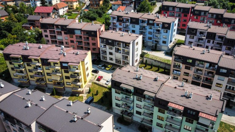 Vastgoed-gedekte vorderingen – luchtfoto van een kleurrijk wooncomplex met meerdere appartementsgebouwen, omgeven door groene zones in Bosnië