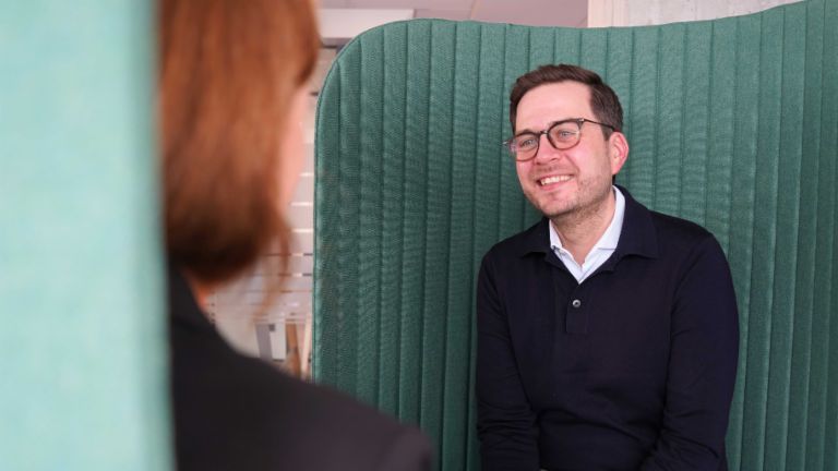 Man in een kantooromgeving tijdens een interview