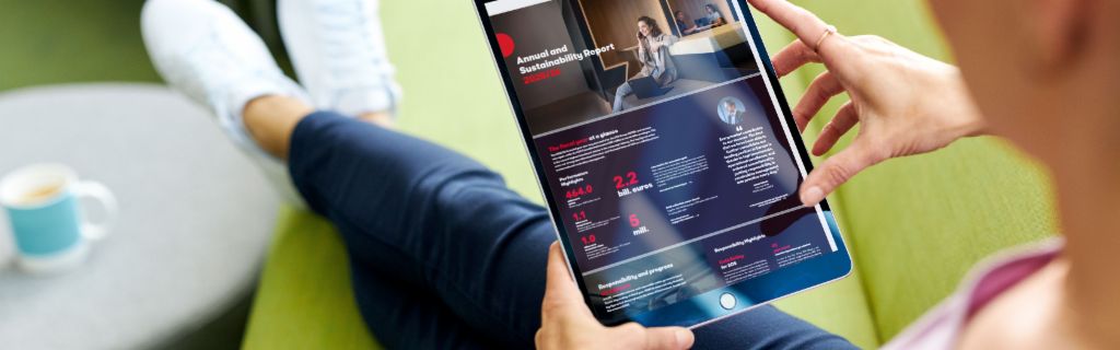 EOS ASR: De afbeelding toont een jonge vrouw die een tablet vasthoudt en daarop het jaarlijkse duurzaamheidsrapport van EOS bekijkt.