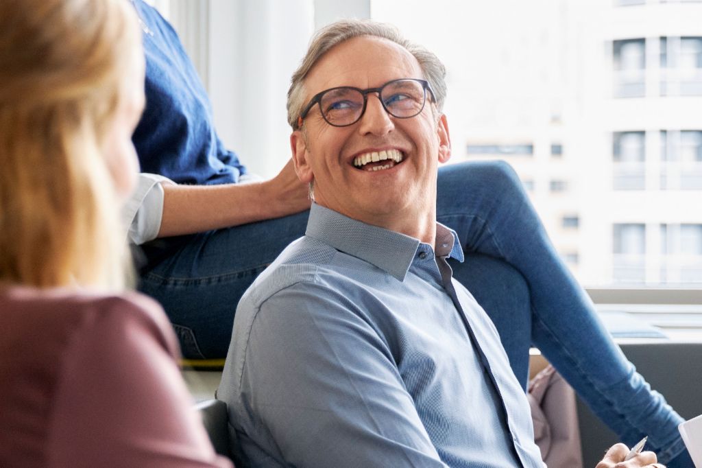 EOS-medewerkers zitten in een modern kantoor en houden een vergadering terwijl ze aantekeningen maken.